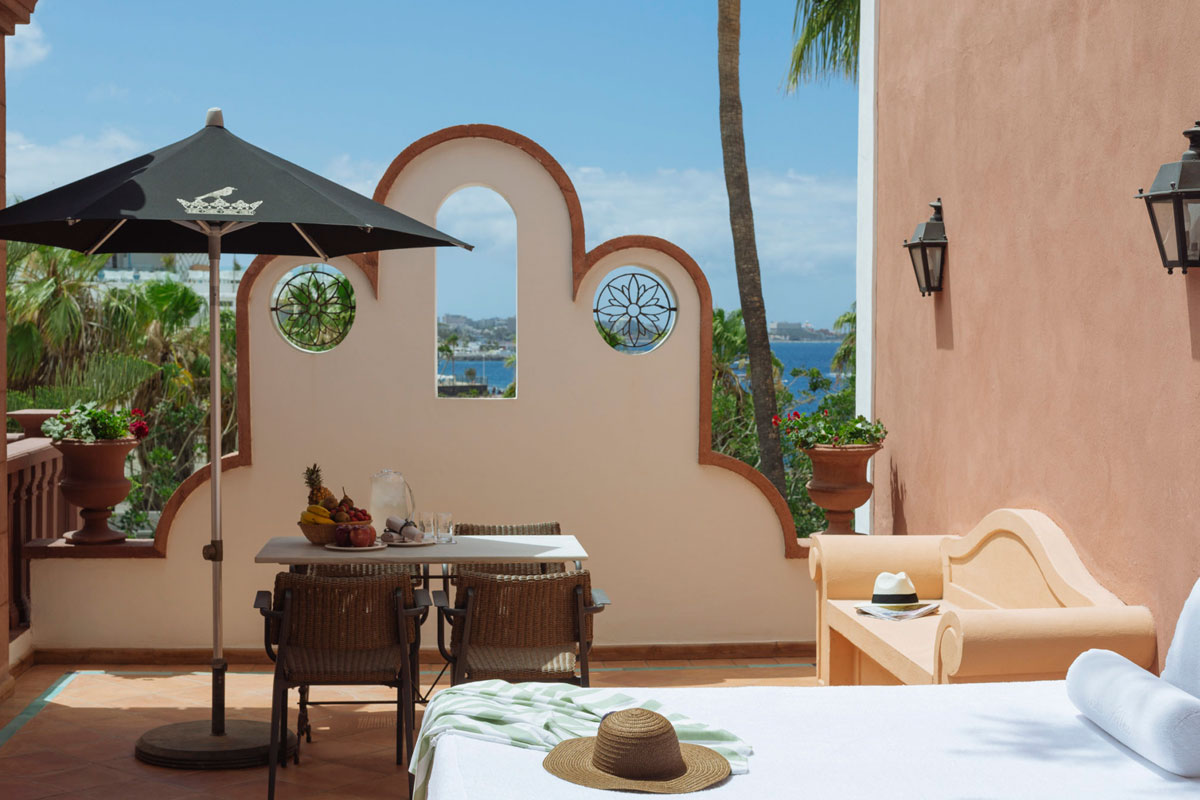 Terrace in Tenerife with table, black umbrella and sea views in the background.