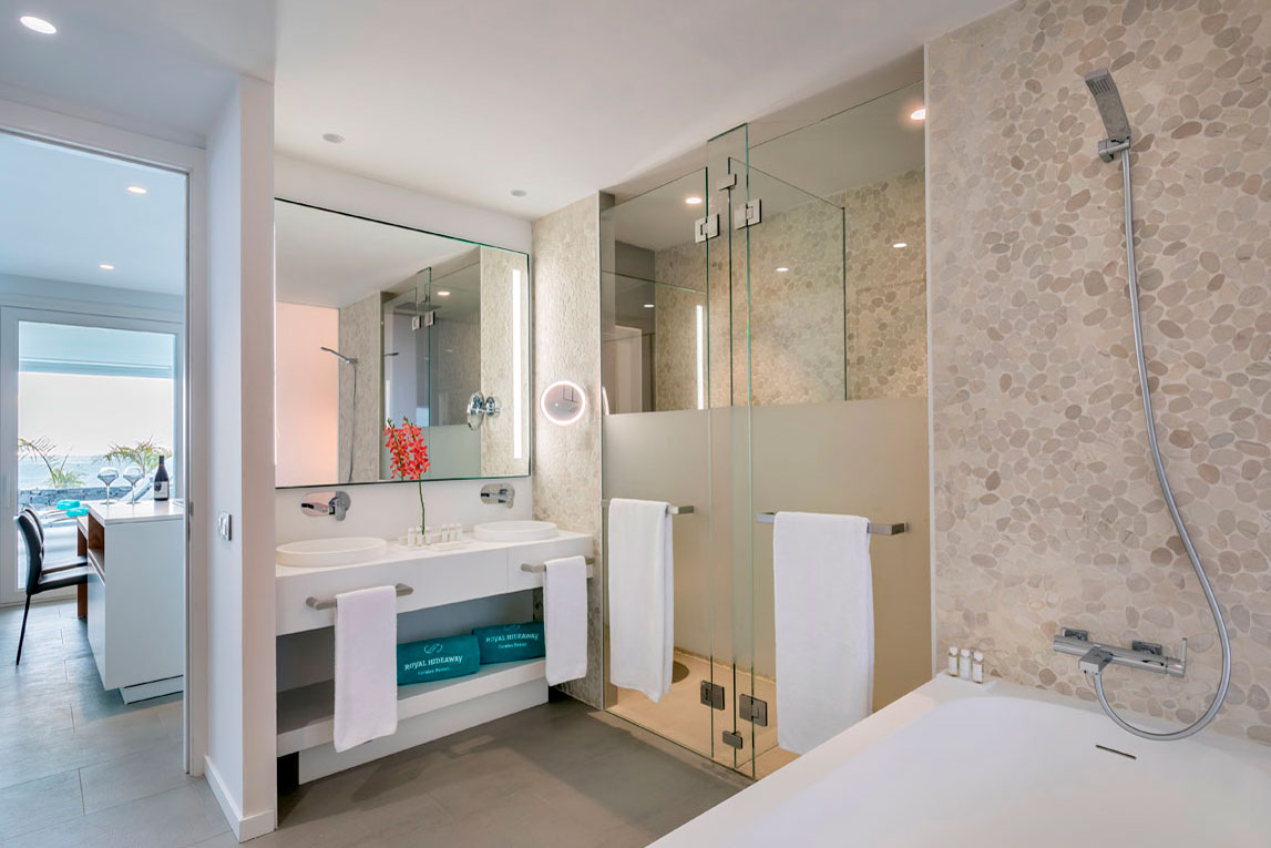 Modern bathroom with glass shower and double sink in a Tenerife hotel.