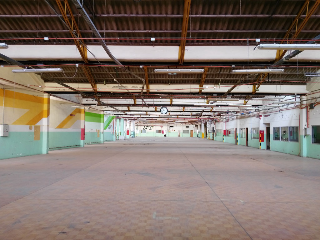 Empty industrial warehouse in Tenerife with high ceiling and colourful walls.