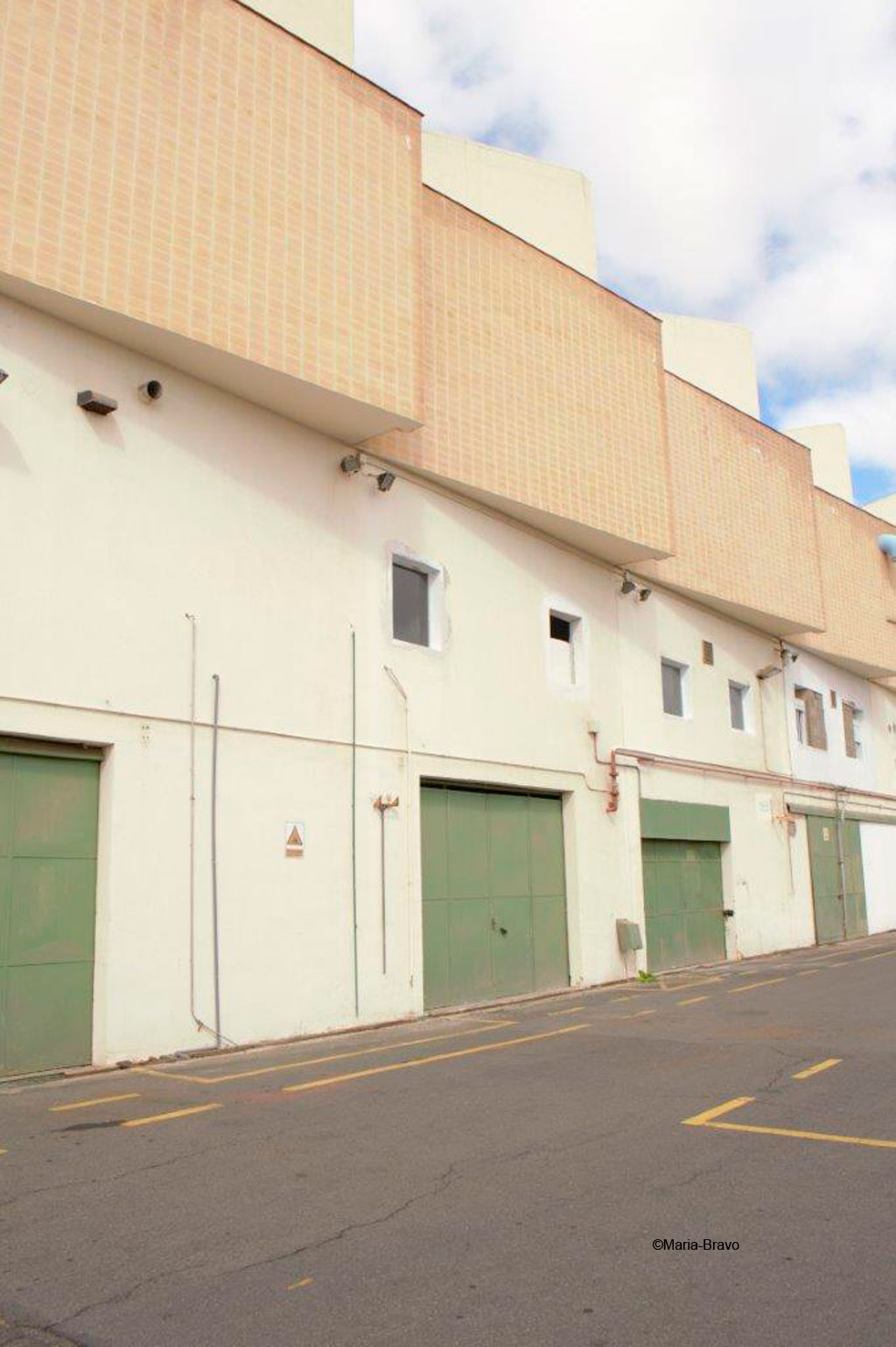 Façade of an industrial building with green gates in Santa Cruz de Tenerife.