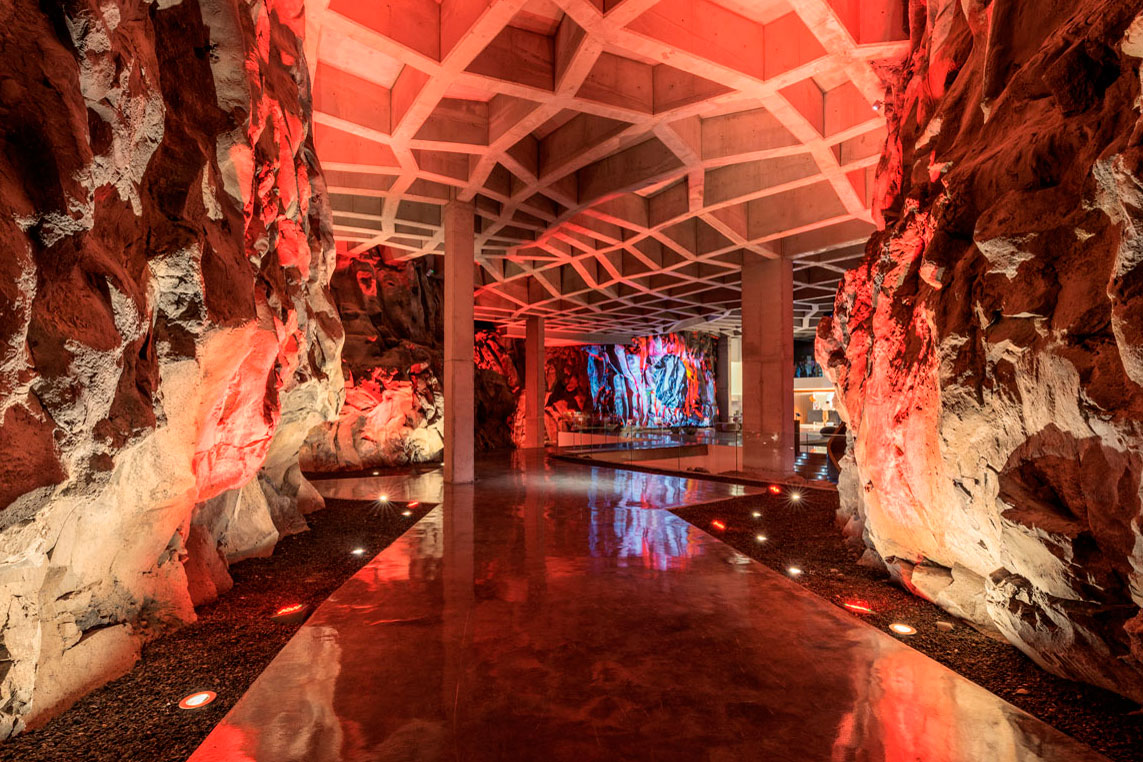 Corridor with ceiling structure and rock walls illuminated in red in Tenerife.
