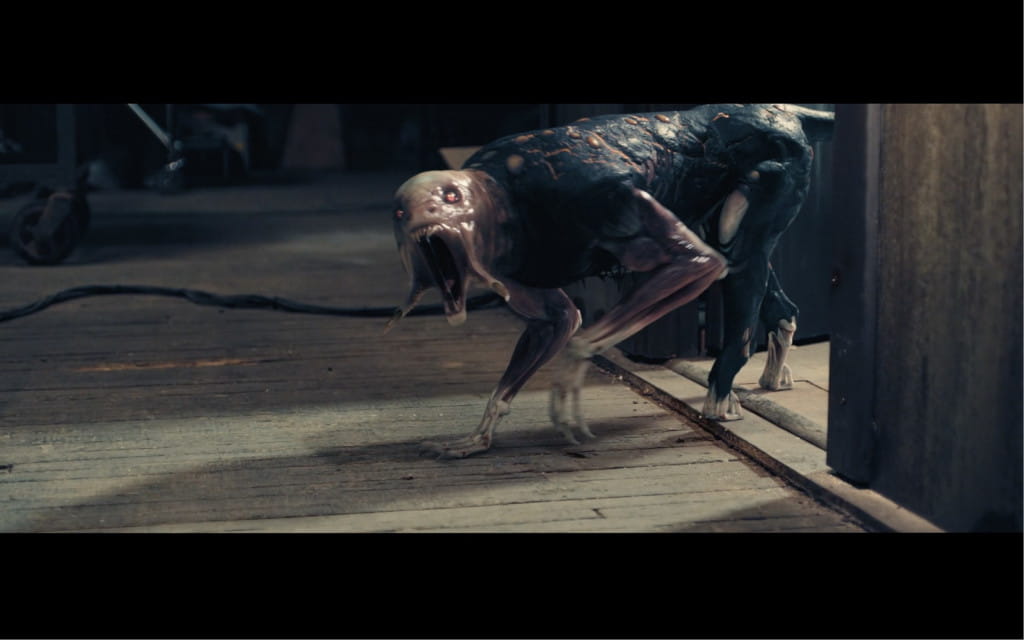 Creature with dark skin and slender limbs on the wooden floor.
