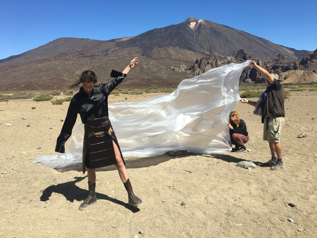 People hold white cloth with the Teide in the background in Tenerife.