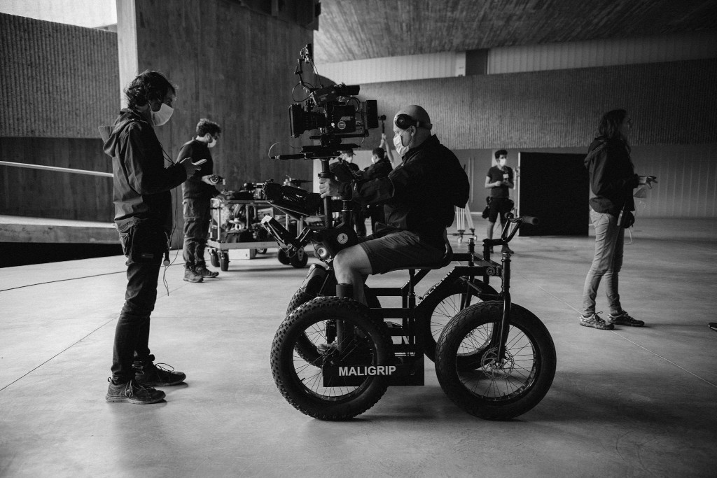Person handling camera in Maligrip in a large indoor space.