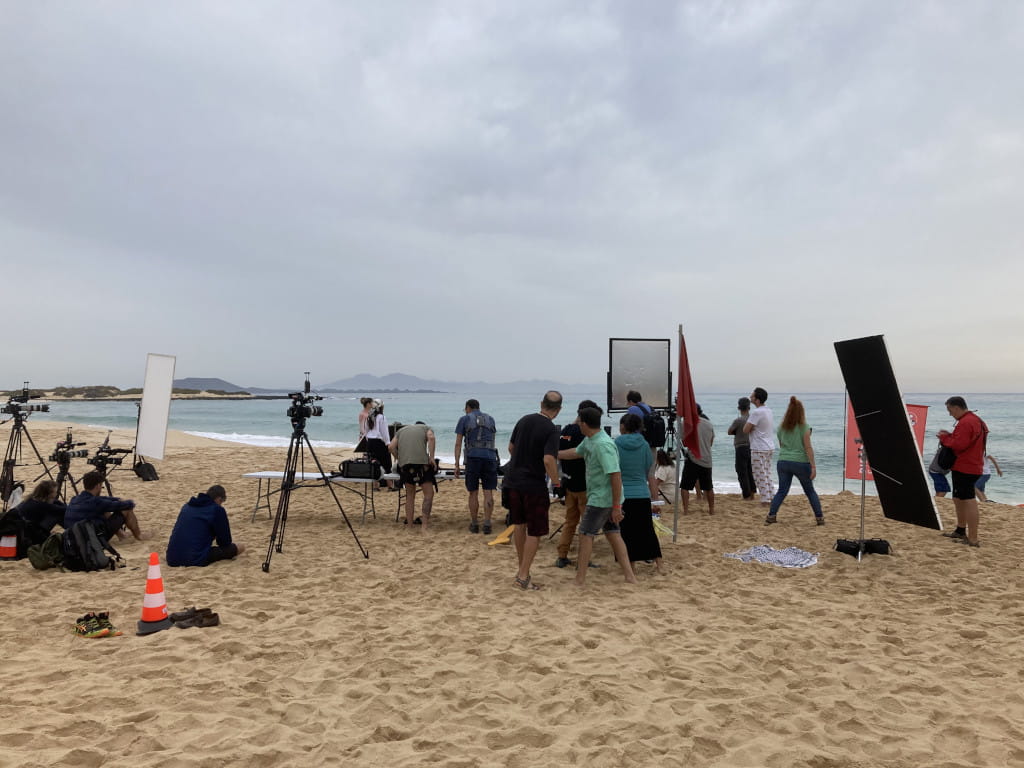 Film crew working on a beach in Tenerife with cameras and microphones.