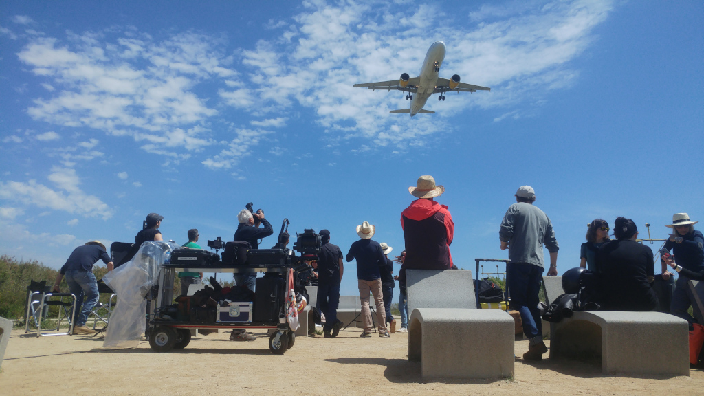 Group of people watching a plane fly low in Tenerife.