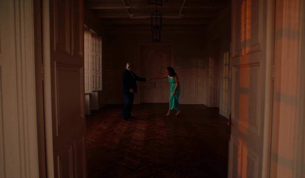 Old and young people dance in a room lit by sunset in Tenerife.