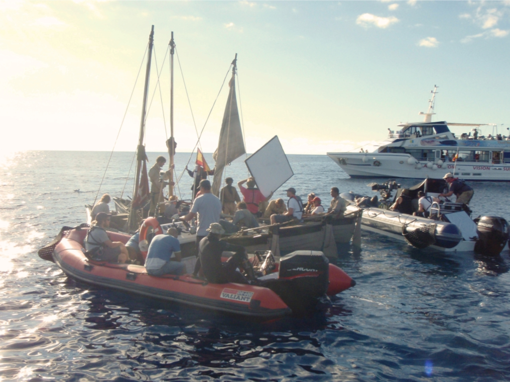 People in inflatable boats and sailboat at sea near Tenerife.
