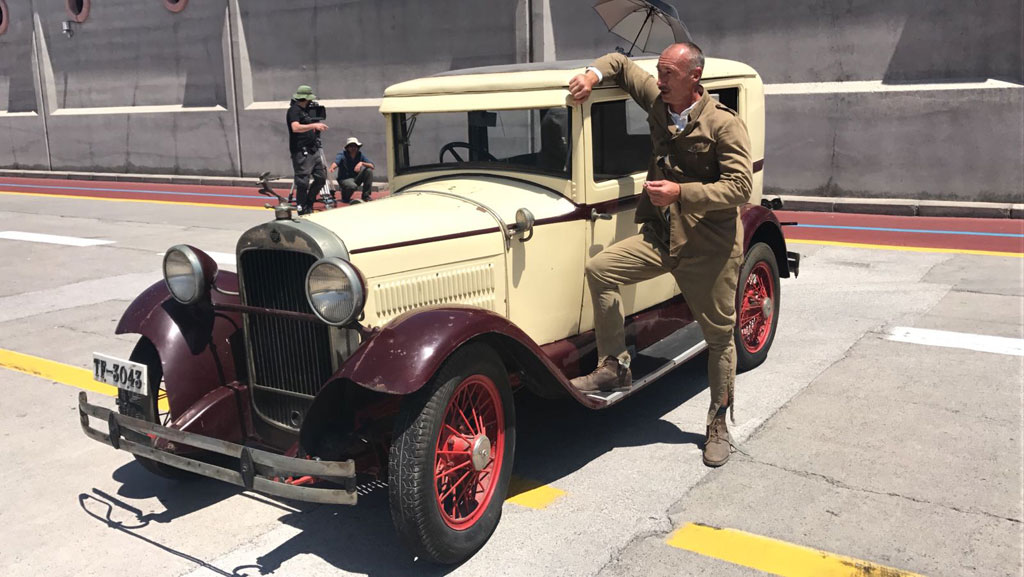 Man leaning on an antique car on a street in Tenerife.