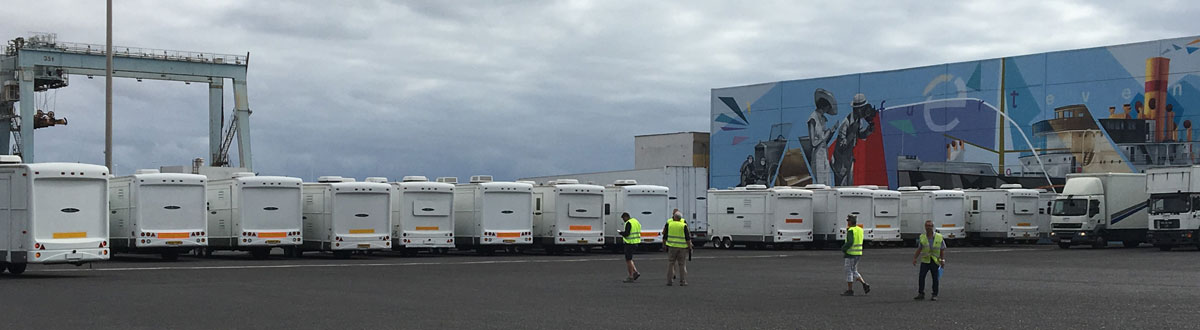 Rows of white trailers and people in vests at the port of Tenerife.