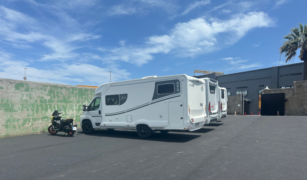 Motorhomes and a motorbike parked in a car park in Tenerife.