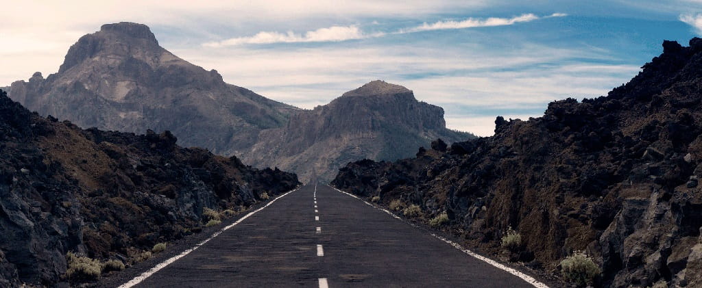 Straight road surrounded by volcanic mountainous landscape on Teide, Tenerife.