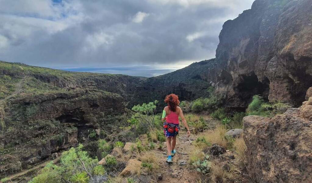 Person walking on a trail through the rocky landscape of Barranco del Infierno, Tenerife.