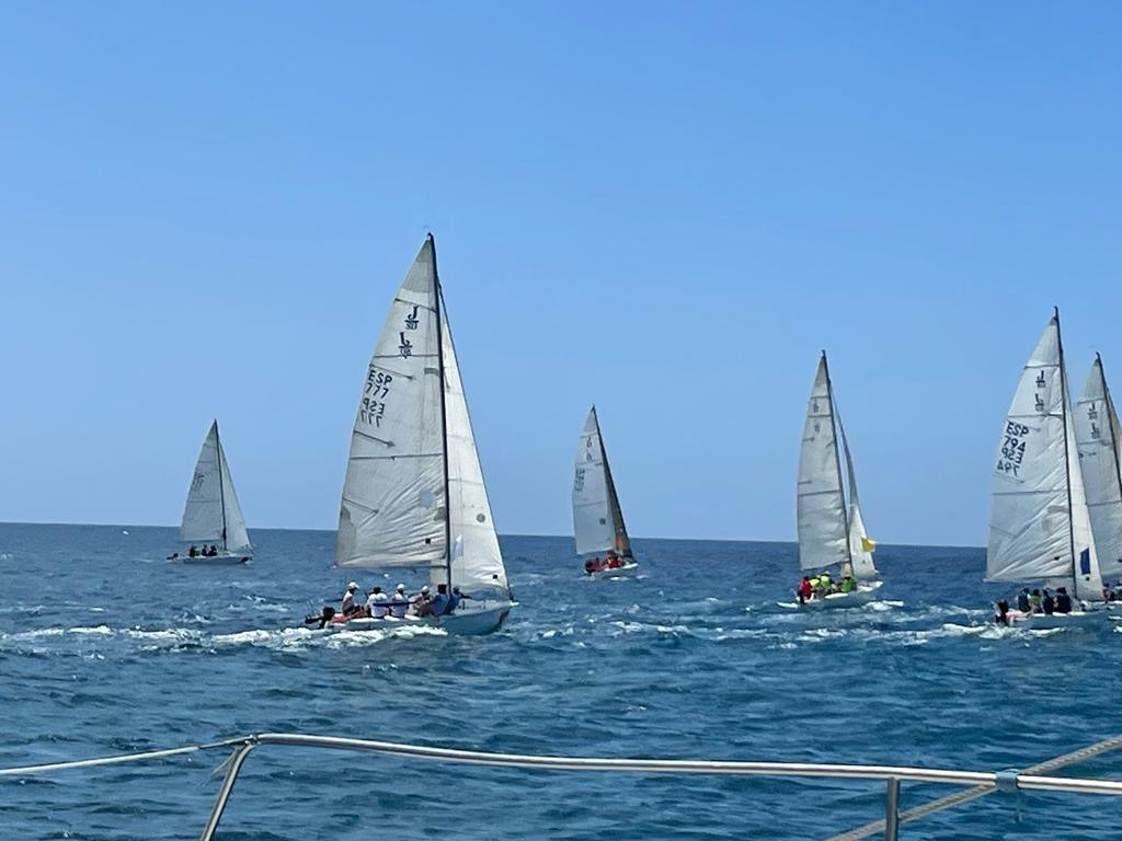 Sailboats racing on the ocean near Tenerife, with blue skies above.