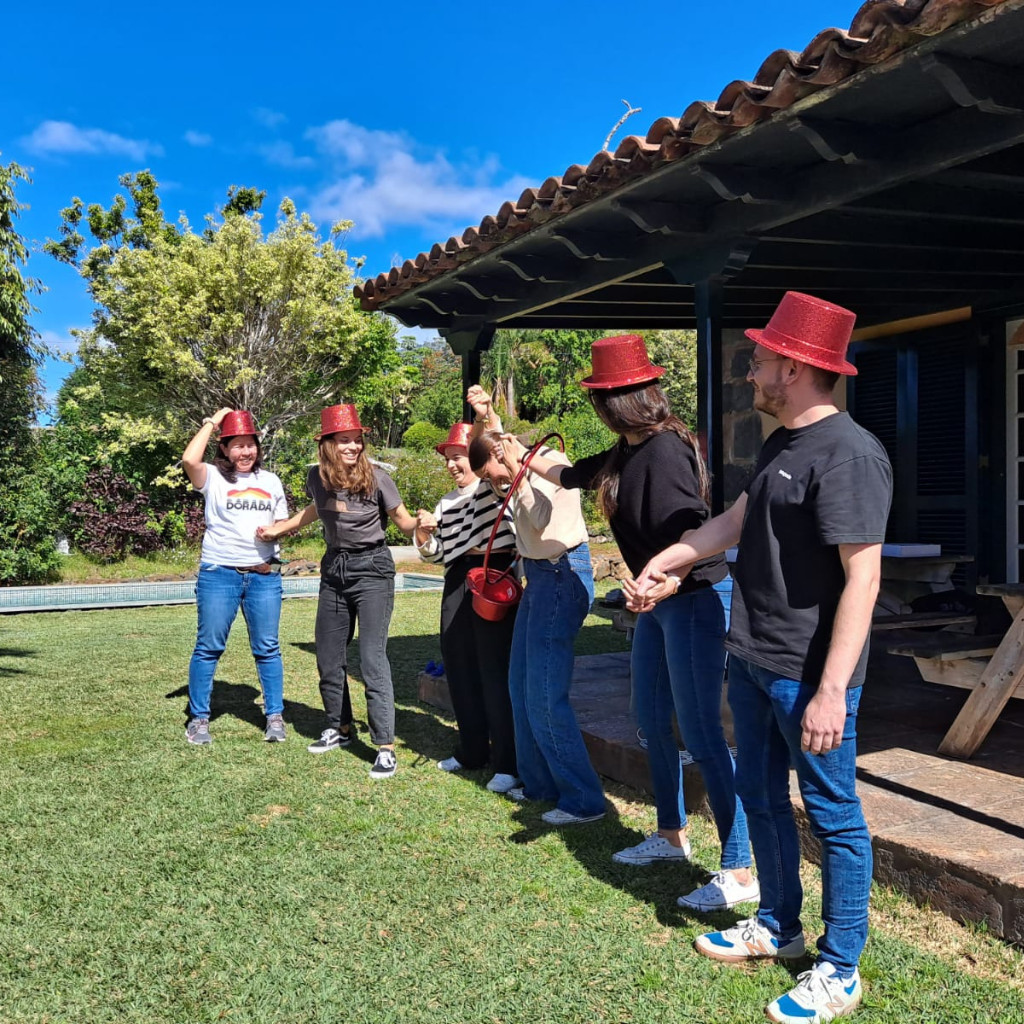 Group of people wearing red hats holding hands outdoors in Tenerife.