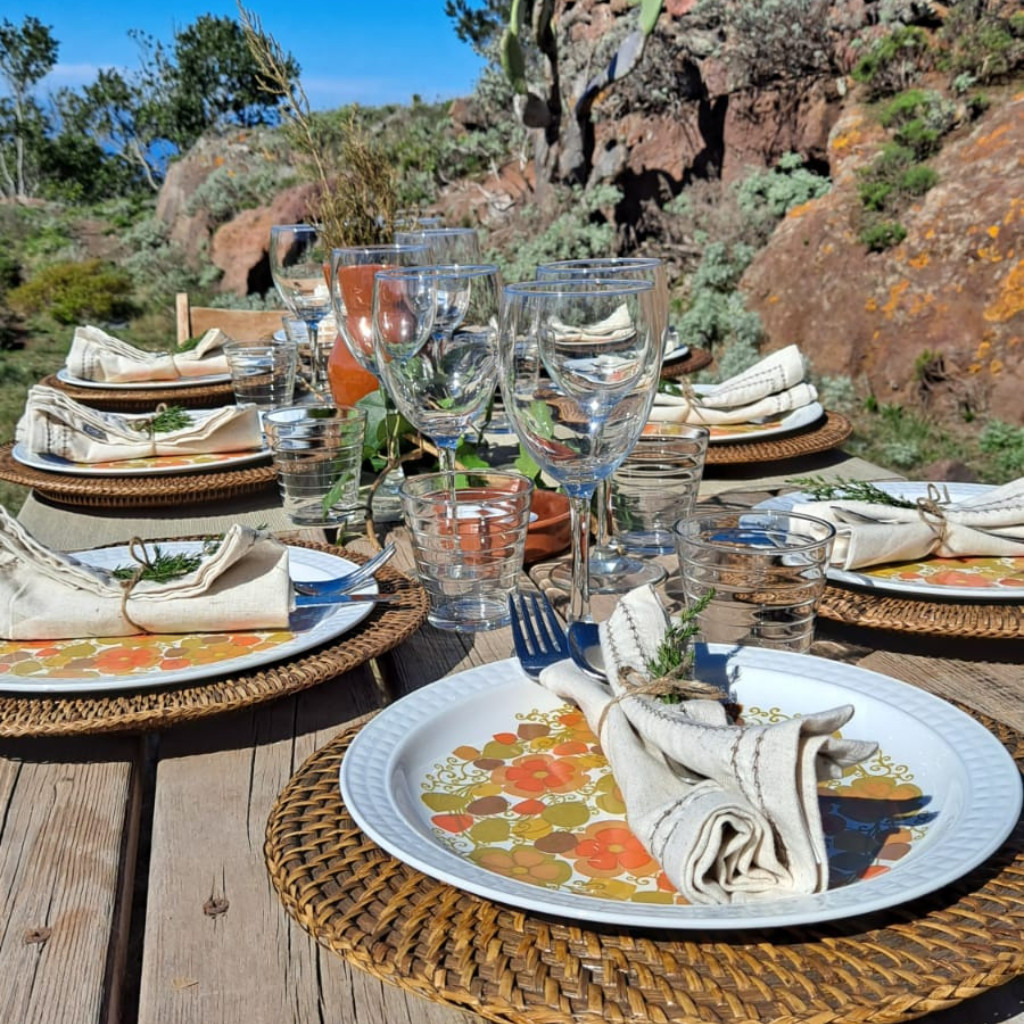 Outdoor dining table setup with floral plates and glasses in Tenerife.