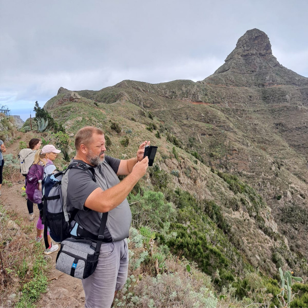 People walking along a path in Tenerife with mountains in the background.