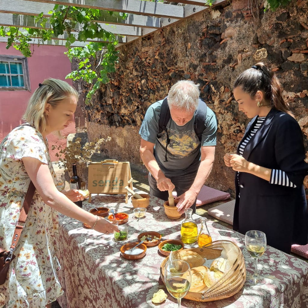 People preparing traditional food at an outdoor table in La Orotava, Tenerife.