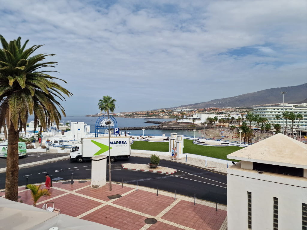 Views of the port of Los Cristianos, Tenerife, with the sea and mountains in the background.