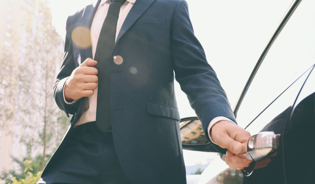 Man in suit opening the door of a car in Tenerife.