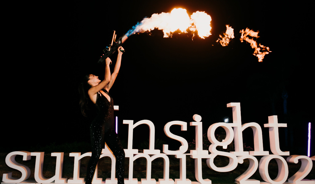 Flamethrower person next to insight summit 2021 letters at a night event in Tenerife.