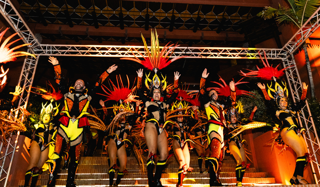 People dancing at the carnival in Tenerife in colorful costumes.