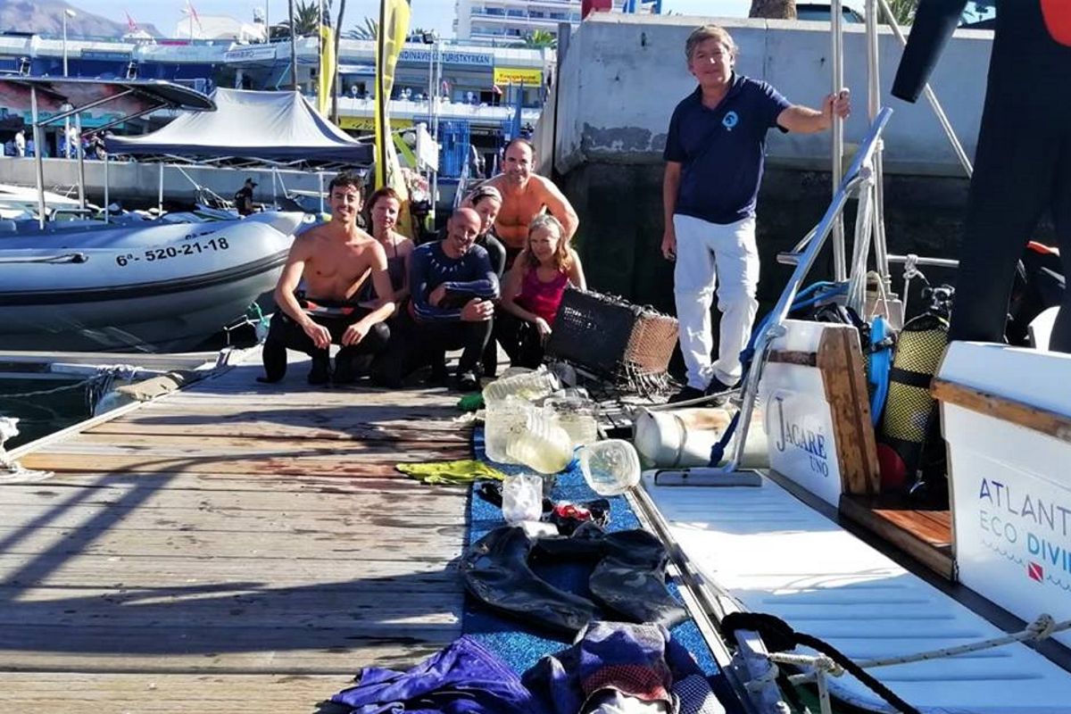 People on the dock with diving equipment and garbage collected in Tenerife.