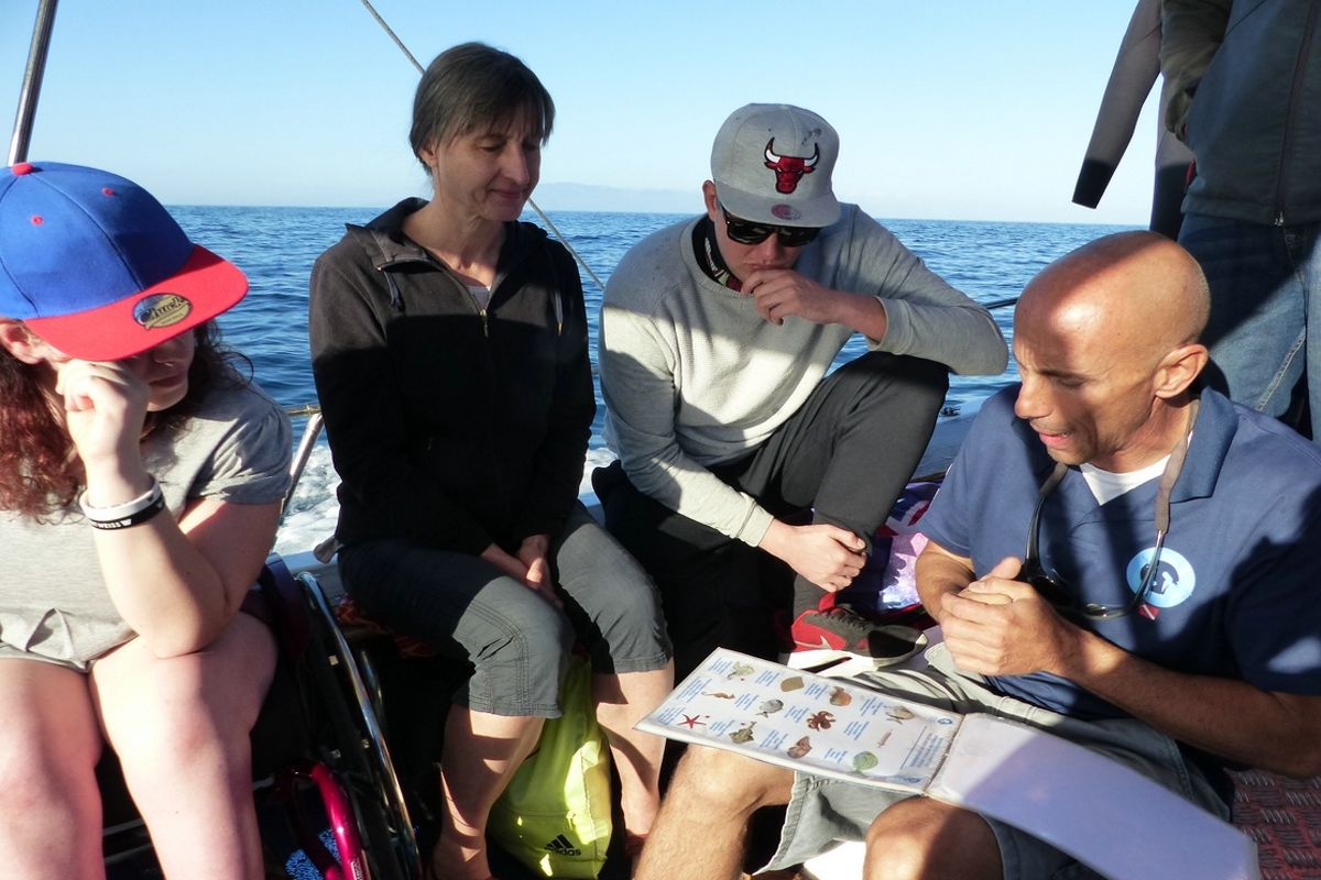 People on a boat in Tenerife look at a list with images and text as they sail.