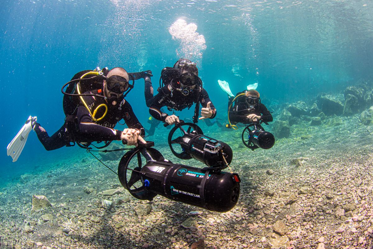 Divers with underwater thrusters exploring crystal clear waters in Tenerife.