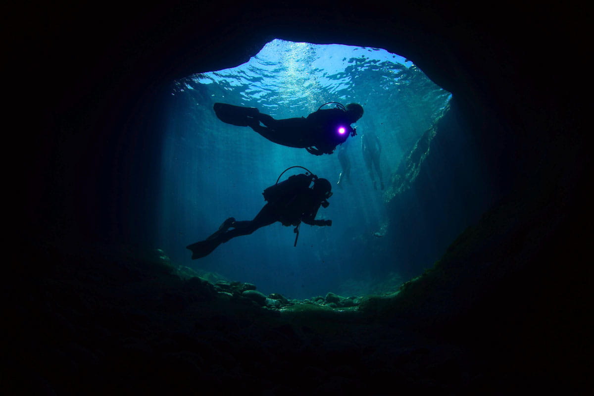 Divers exploring an underwater cave in Tenerife.