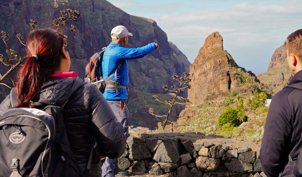 Hikers observe the mountainous landscape in Masca, Tenerife.