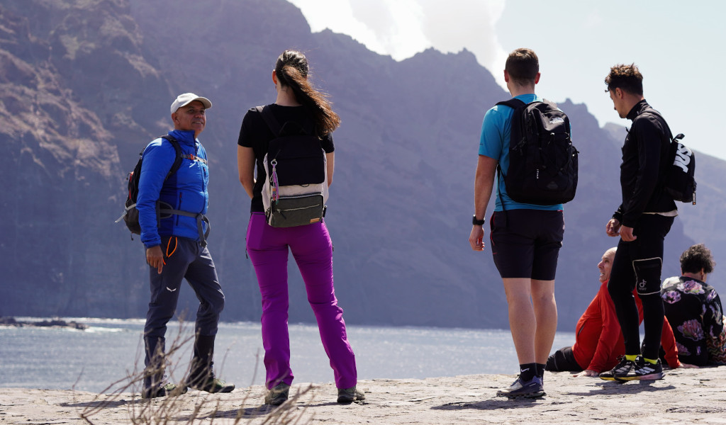 Group of people with backpacks in front of cliffs in Tenerife.