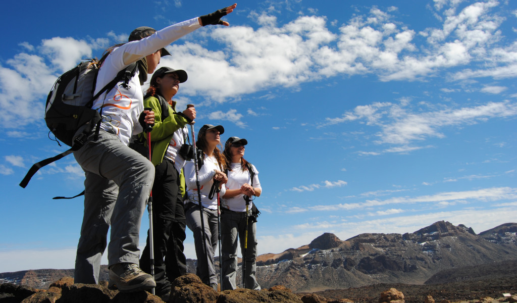 Group of hikers in the Teide National Park, Tenerife, with mountains in the background.