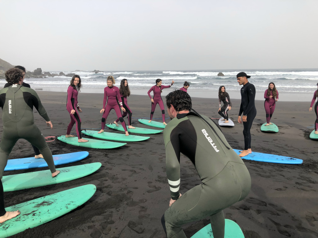 Group of people learning to surf on the beach of Tenerife.