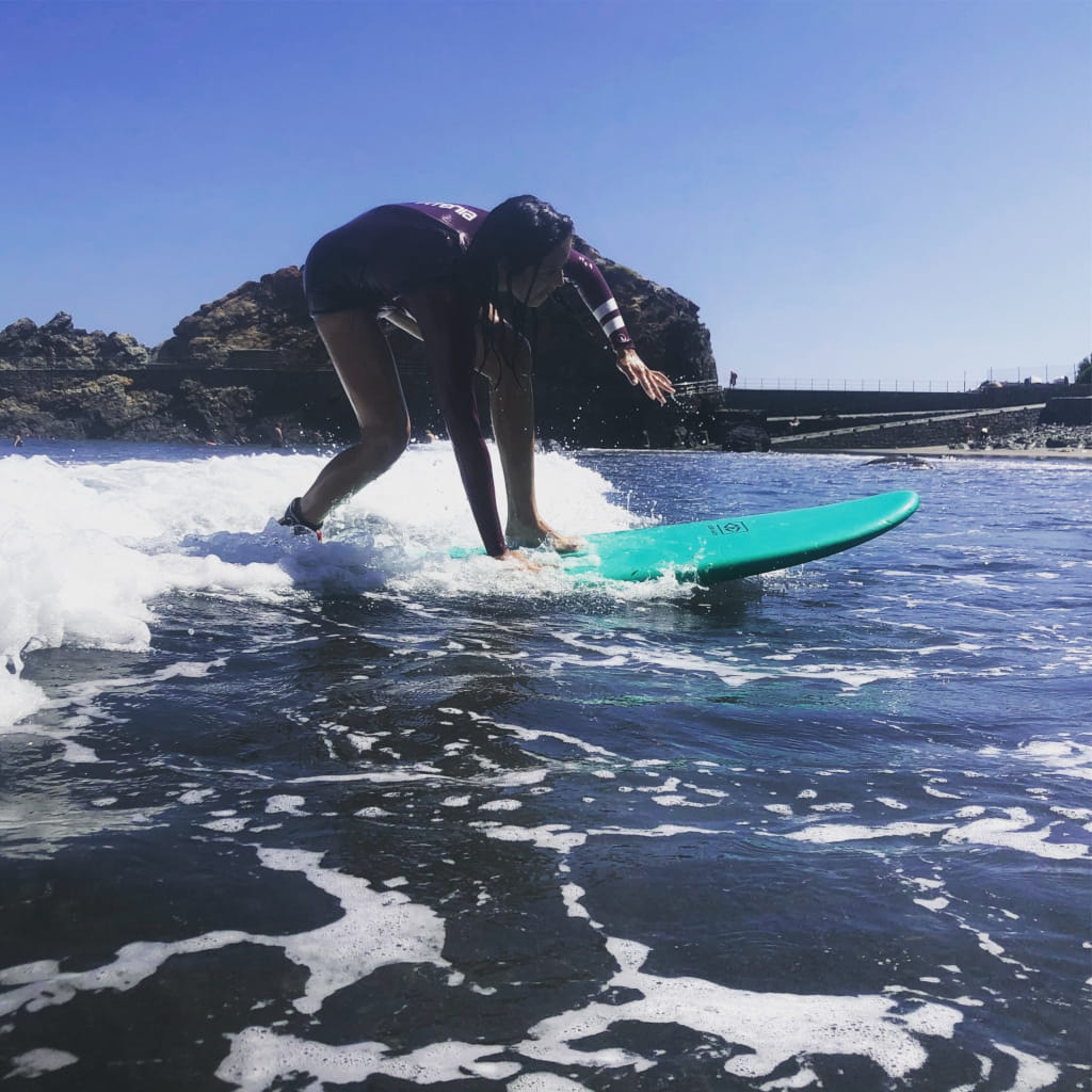 Surfer on a greenboard on a wave off the coast of Garachico, Tenerife.