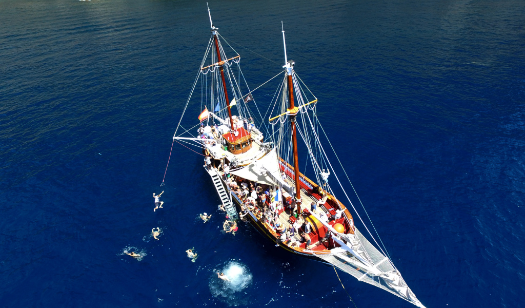 Tourist boat with people swimming near Tenerife.