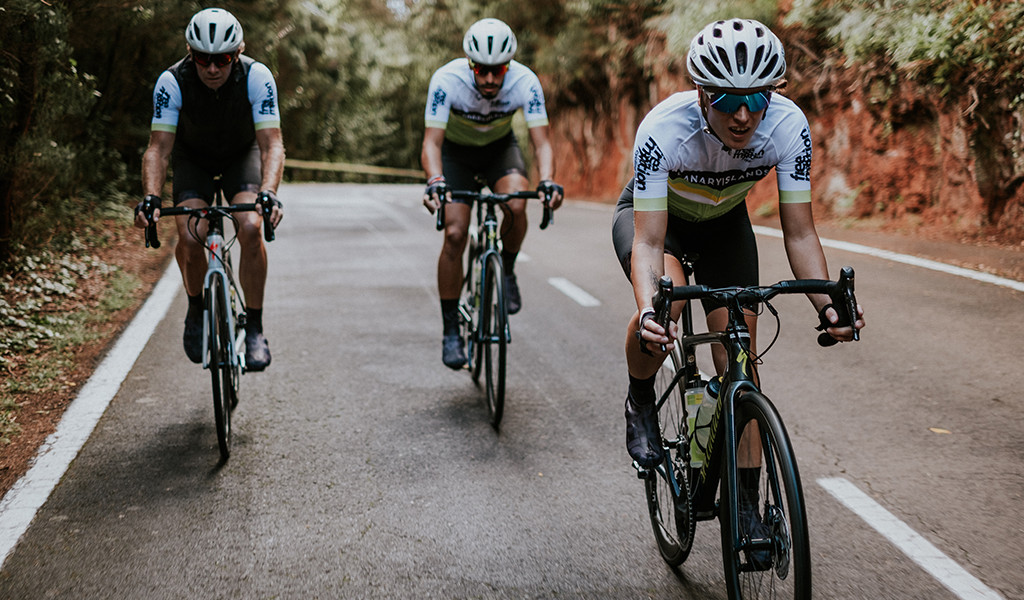 Cyclists on the road surrounded by greenery in Tenerife.