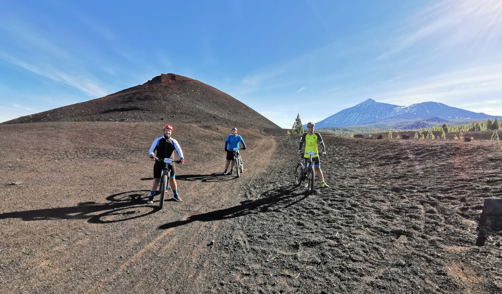 Cyclists in a volcanic landscape near Mount Teide, Tenerife.