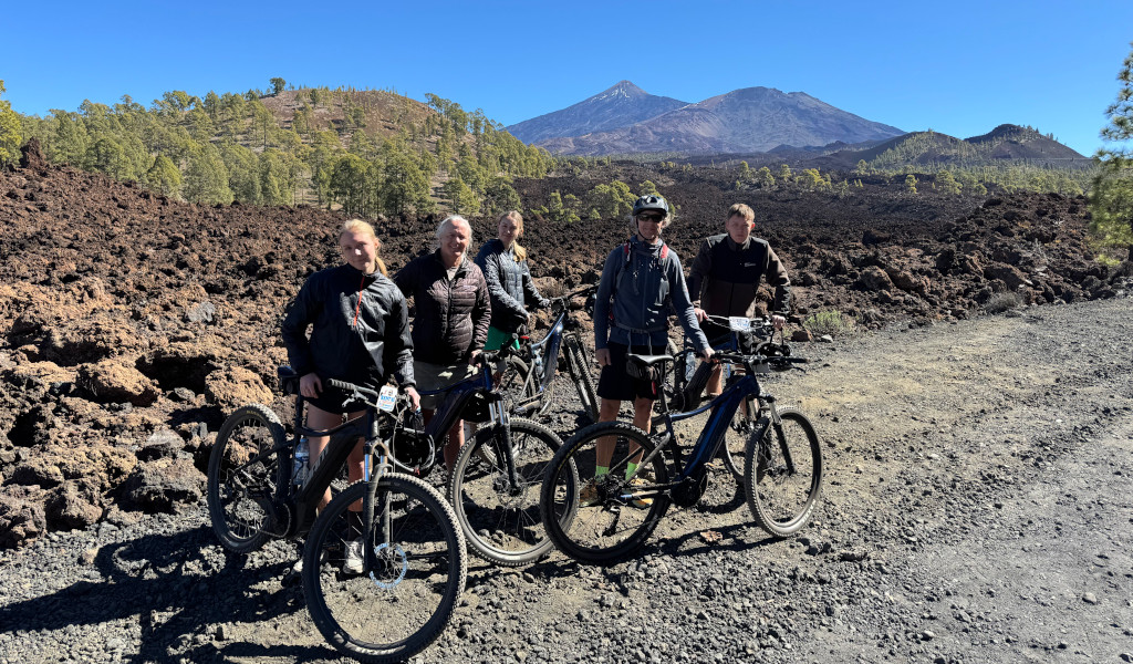 Cyclists on a volcanic trail with Mount Teide in the background in Tenerife.