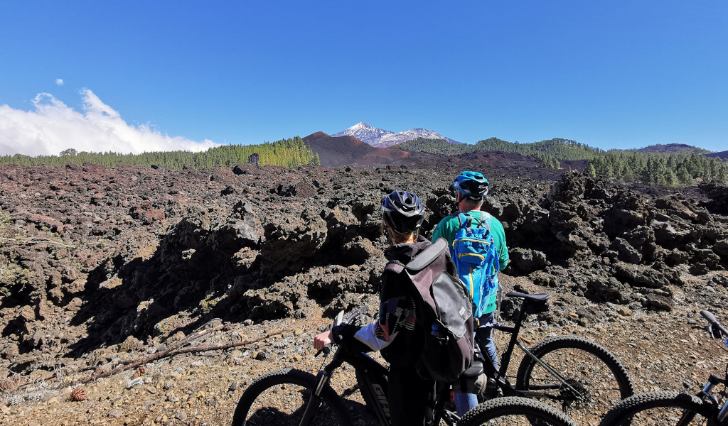 Two cyclists look at the volcanic landscape near Mount Teide in Tenerife.