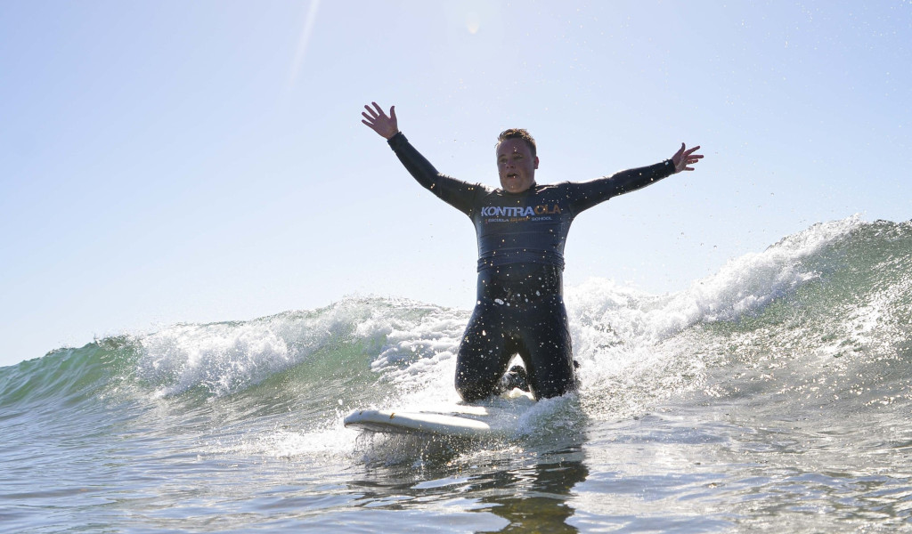 Surfer on wave with outstretched arms, Kontraola t-shirt. Surfing in Tenerife.