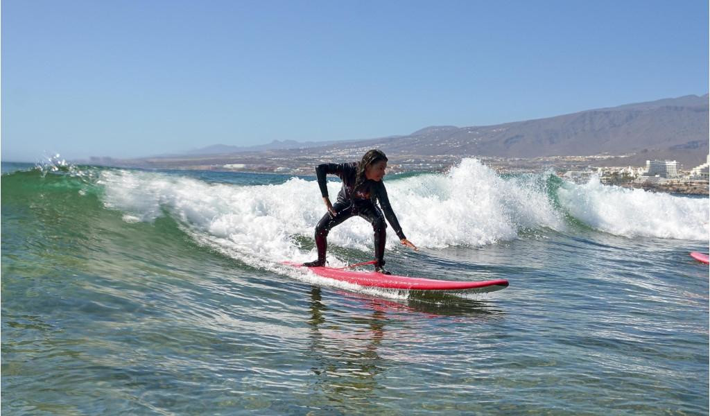 Person surfing a wave in Playa de Las Americas, Tenerife.