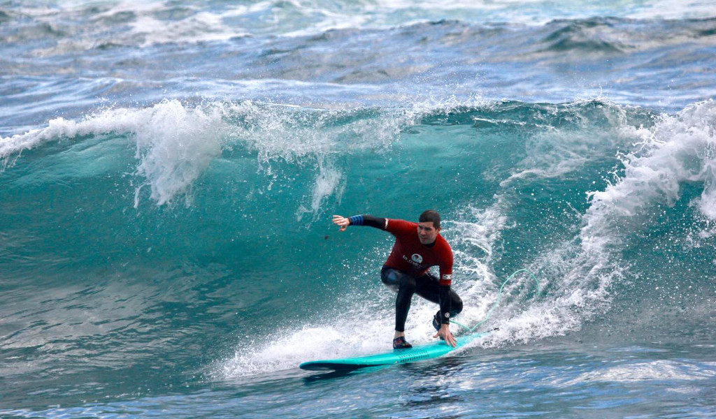 Surfer riding a wave on the beach in Tenerife.