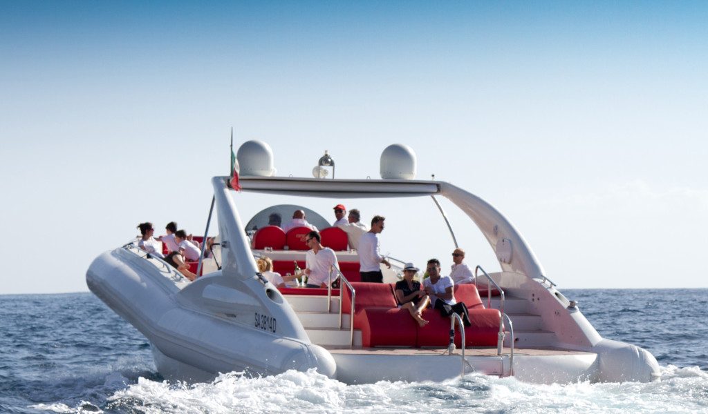 People enjoying a ride on a boat with red seats in the sea near Tenerife.