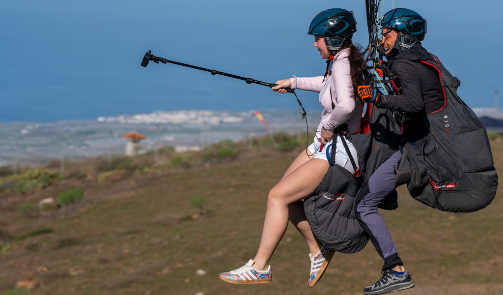 Two people paragliding over a landscape of Tenerife.