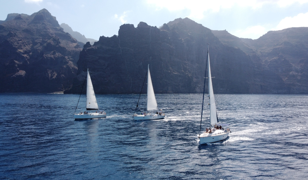 Sailboats sailing near the cliffs of Los Gigantes in Tenerife.