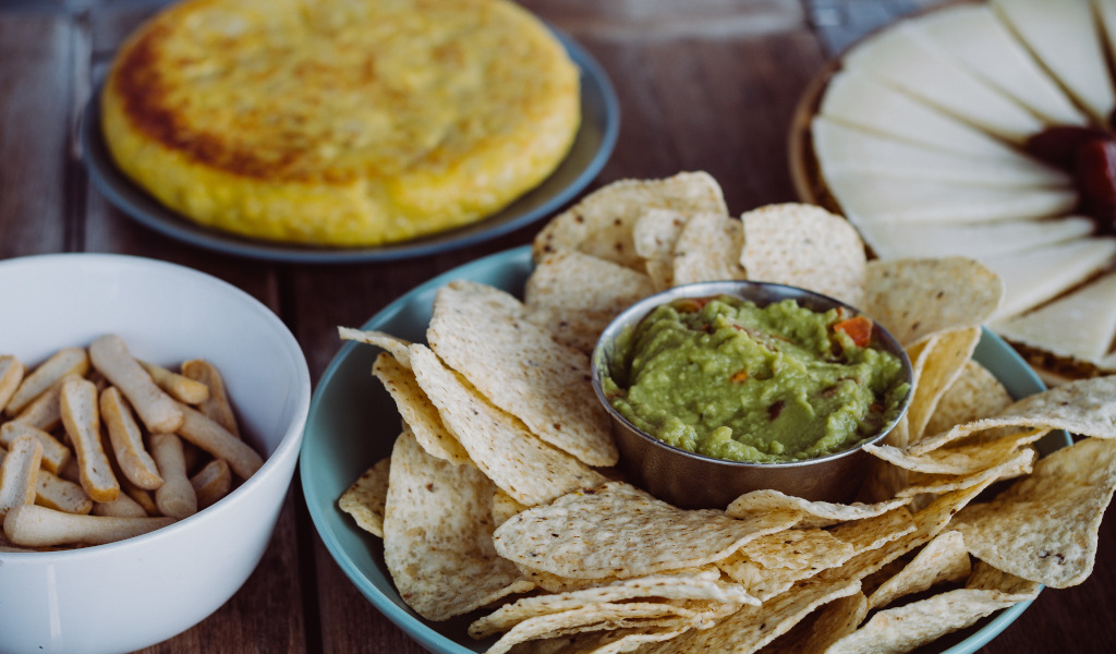 Nachos with guacamole, breadsticks, tortilla and cheese on a table in Tenerife.