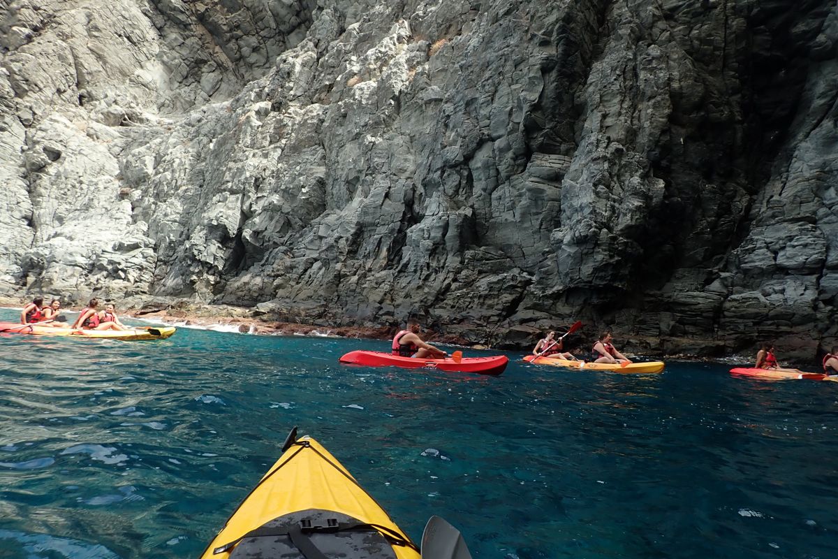 People kayaking along cliffs on the coast of Tenerife.