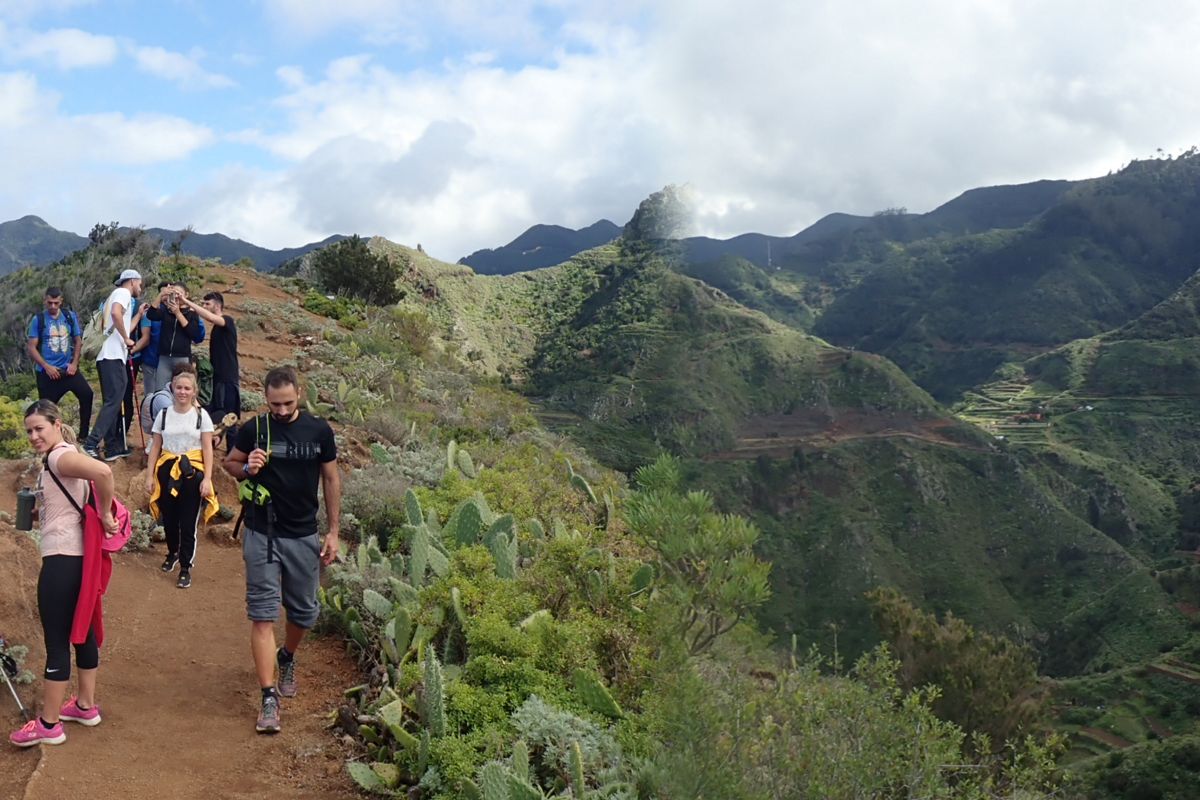 Trail with people walking in the Anaga Rural Park, Tenerife. Mountains in the background.