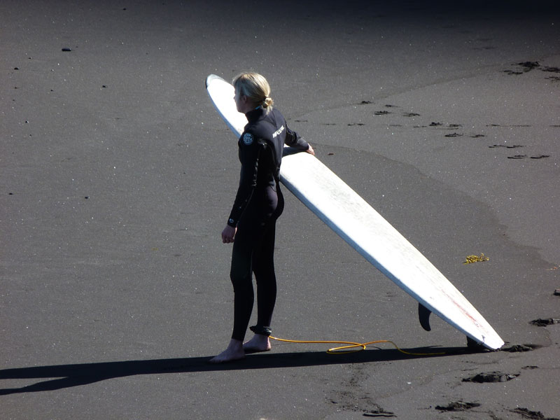 Surfer on the sand with a board in Playa de Tenerife.